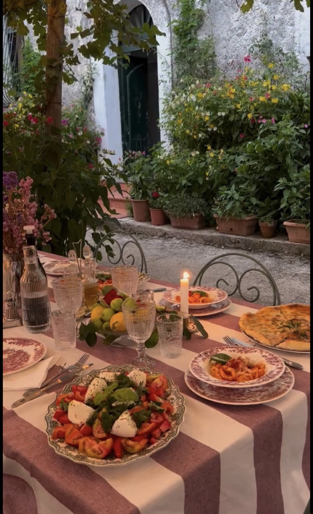 A candlelit garden table set for a shared meal